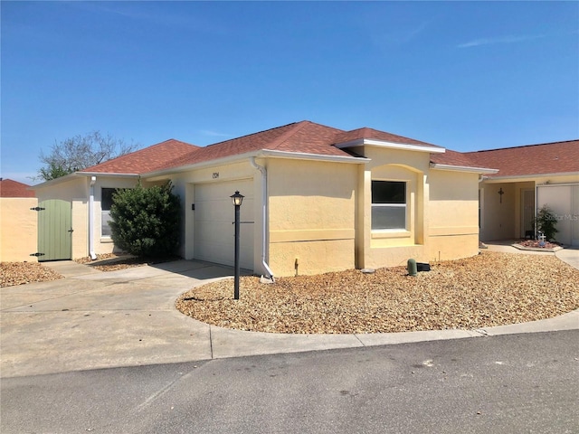 1324 Balboa Ct, The Villages, FL 32159 - view of front of house with driveway, an attached garage, and stucco siding