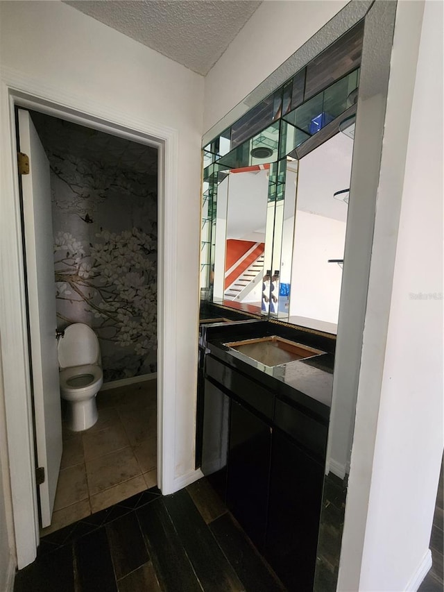 4942 Samoa Cir Unit 5, Orlando, FL 32808 - bathroom featuring a textured ceiling, baseboards, toilet, vanity, and tile patterned flooring
