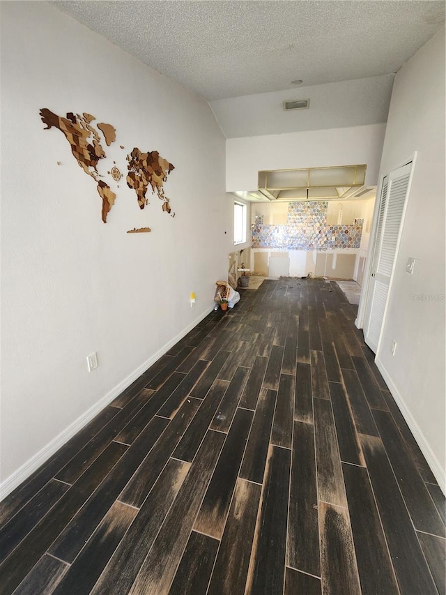 4942 Samoa Cir Unit 5, Orlando, FL 32808 - corridor featuring a textured ceiling, lofted ceiling, baseboards, wood tiled floor, and visible vents