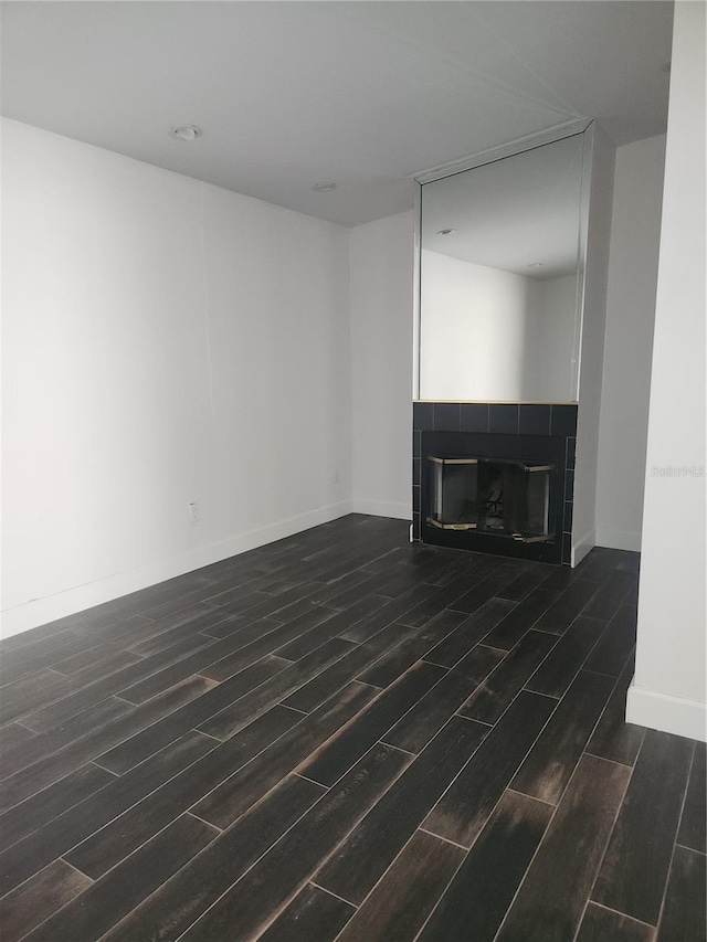 4942 Samoa Cir Unit 5, Orlando, FL 32808 - unfurnished living room featuring a tile fireplace, baseboards, and wood tiled floor