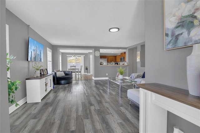 1510 Pier St, Clermont, FL 34711 - living room featuring a chandelier, dark wood finished floors, and baseboards