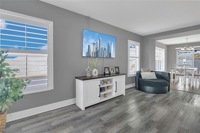 1510 Pier St, Clermont, FL 34711 - living room featuring baseboards, wood finished floors, and a notable chandelier