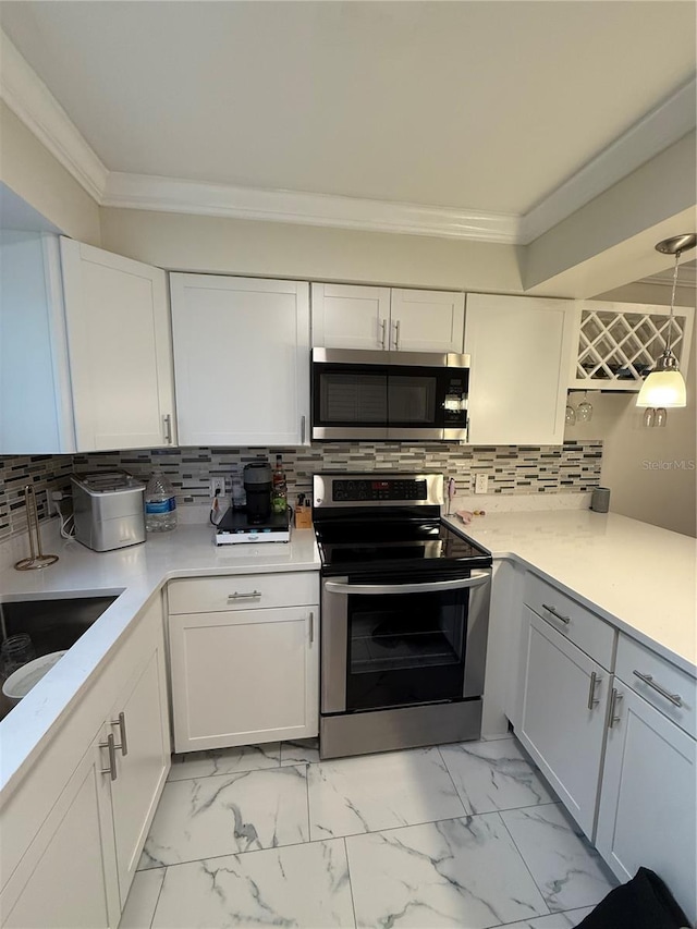 kitchen featuring marble finish floor, white cabinets, stainless steel appliances, and crown molding