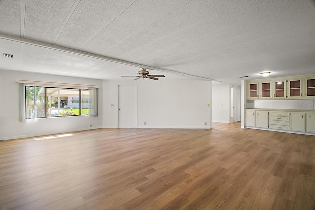 unfurnished living room with visible vents, baseboards, light wood finished floors, and ceiling fan