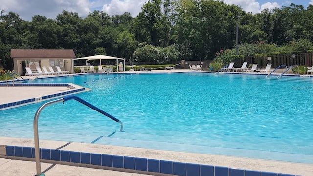 pool with fence and a patio area