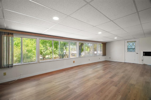 spare room with a paneled ceiling, recessed lighting, baseboards, and wood finished floors