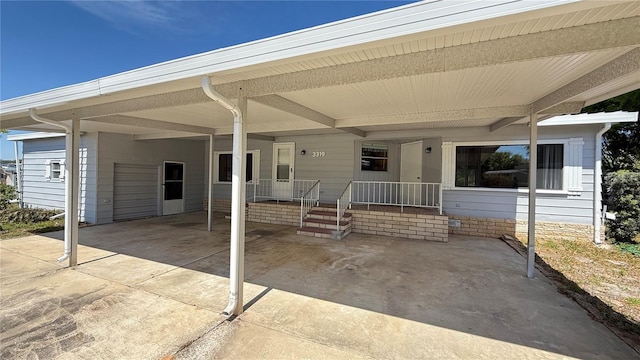 view of patio featuring covered porch, an attached carport, and driveway