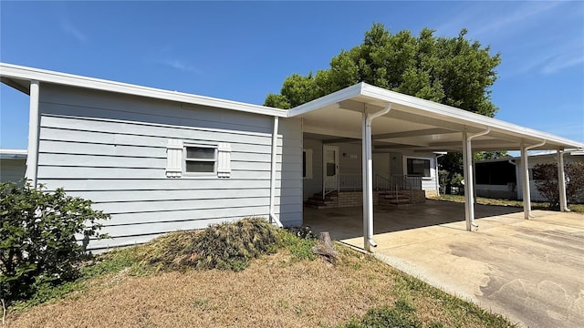 view of home's exterior featuring a carport, entry steps, and concrete driveway