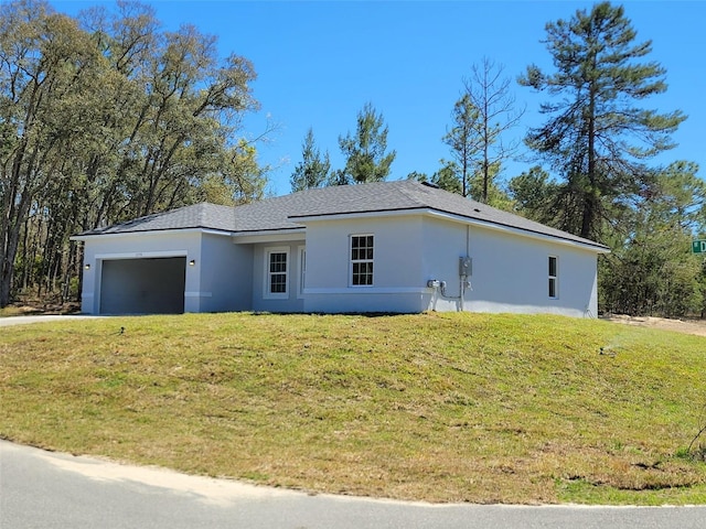 view of front of house with a front lawn, driveway, stucco siding, and an attached garage
