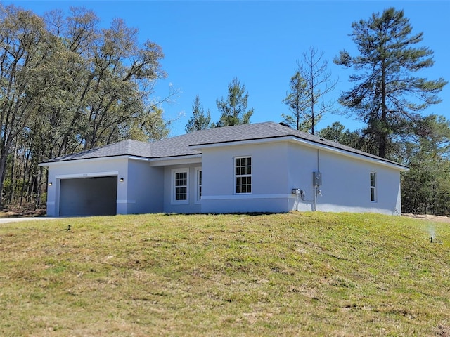 view of front of home featuring a front lawn, stucco siding, and a garage