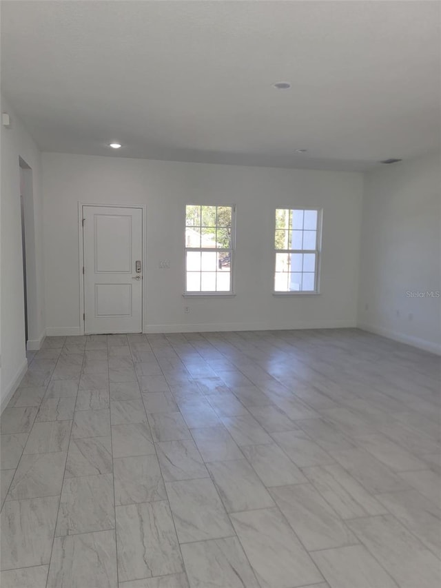unfurnished room featuring baseboards and recessed lighting