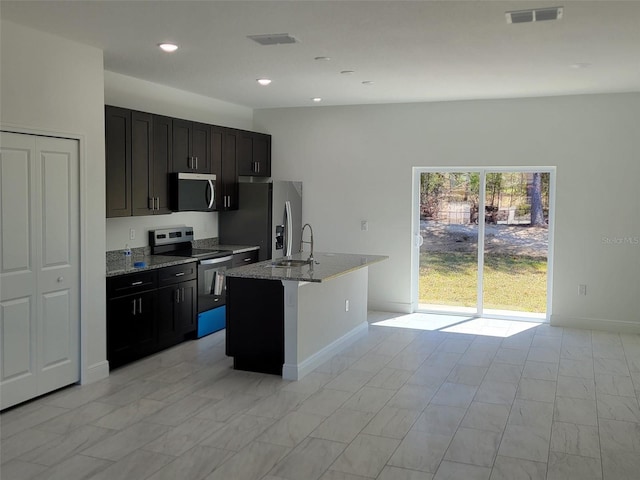 kitchen featuring a sink, light stone countertops, visible vents, and appliances with stainless steel finishes