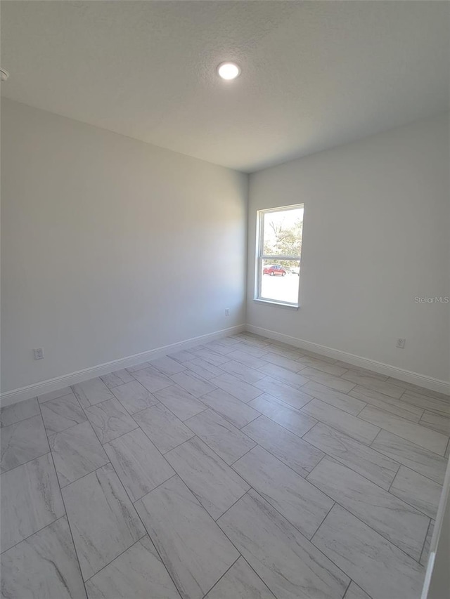 empty room featuring baseboards and a textured ceiling
