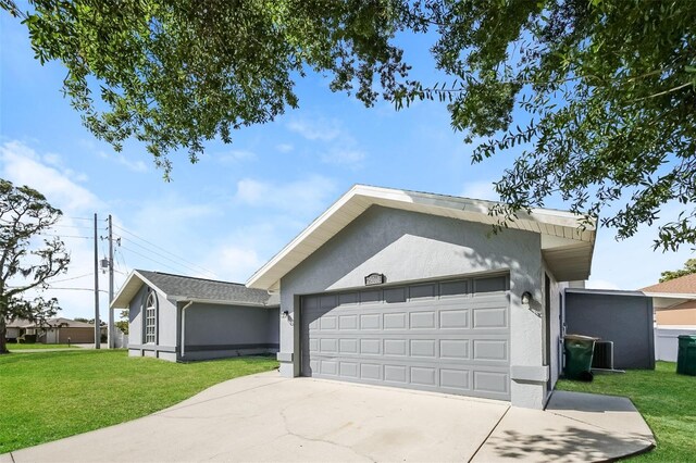 ranch-style home with a front yard, concrete driveway, and stucco siding