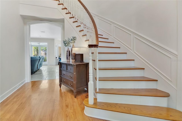 1560 Woodland Ave, Winter Park, FL 32789 - stairway with arched walkways, wood finished floors, and a decorative wall