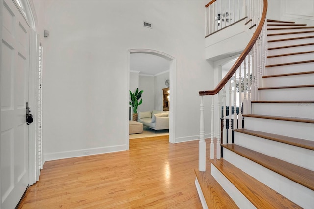 1560 Woodland Ave, Winter Park, FL 32789 - entryway featuring light wood-style flooring, visible vents, stairway, arched walkways, and a high ceiling
