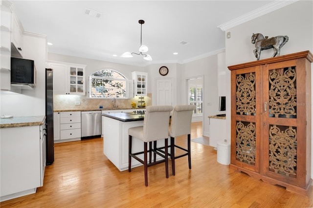 1560 Woodland Ave, Winter Park, FL 32789 - kitchen featuring white cabinetry, stainless steel dishwasher, light wood-style flooring, visible vents, and decorative backsplash