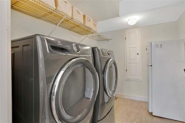 1560 Woodland Ave, Winter Park, FL 32789 - laundry room featuring light tile patterned floors, laundry area, baseboards, and separate washer and dryer