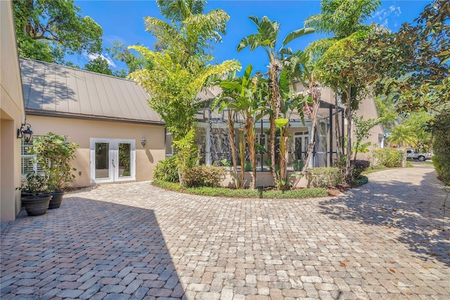 1560 Woodland Ave, Winter Park, FL 32789 - rear view of property with metal roof, stucco siding, a lanai, and french doors