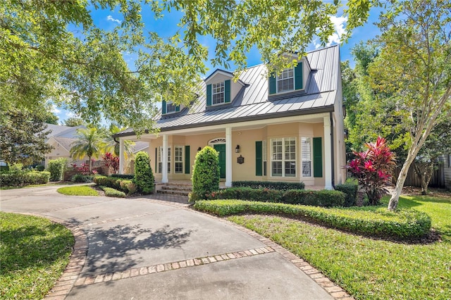 1560 Woodland Ave, Winter Park, FL 32789 - view of front of property featuring driveway, metal roof, a standing seam roof, and covered porch