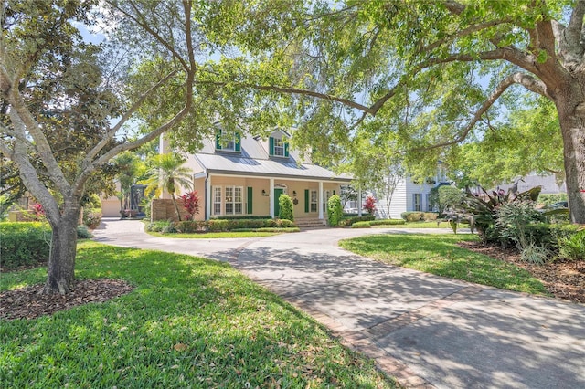 1560 Woodland Ave, Winter Park, FL 32789 - view of front facade with curved driveway, stucco siding, a standing seam roof, metal roof, and a front yard