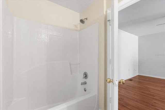 2741 Merrieweather Ln, Kissimmee, FL 34743 - bathroom with baseboards, wood finished floors, and shower / bath combination