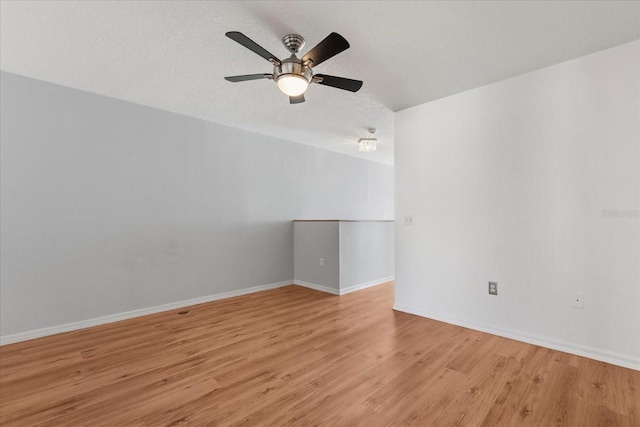 2741 Merrieweather Ln, Kissimmee, FL 34743 - empty room featuring a textured ceiling, light wood-type flooring, baseboards, and a ceiling fan