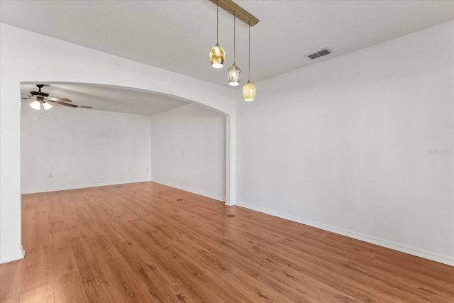 2741 Merrieweather Ln, Kissimmee, FL 34743 - spare room with visible vents, baseboards, ceiling fan, arched walkways, and light wood-style floors