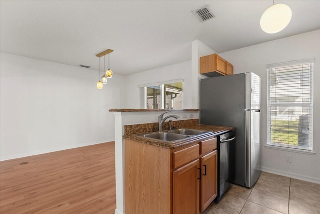 2741 Merrieweather Ln, Kissimmee, FL 34743 - kitchen with decorative light fixtures, a sink, dark countertops, visible vents, and dishwasher