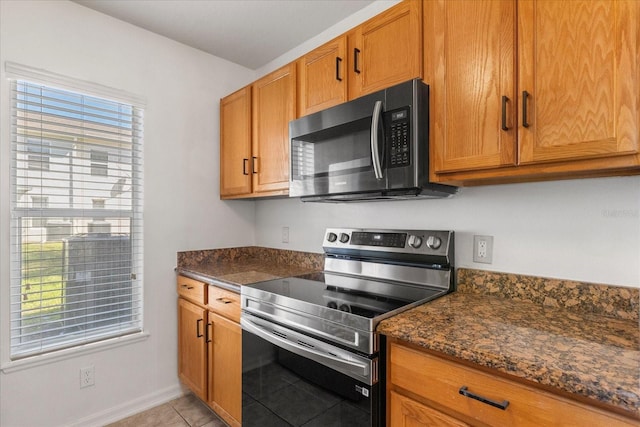 2741 Merrieweather Ln, Kissimmee, FL 34743 - kitchen featuring plenty of natural light, brown cabinetry, and electric range
