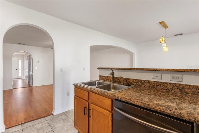 2741 Merrieweather Ln, Kissimmee, FL 34743 - kitchen featuring stainless steel dishwasher, a sink, dark countertops, light tile patterned flooring, and visible vents