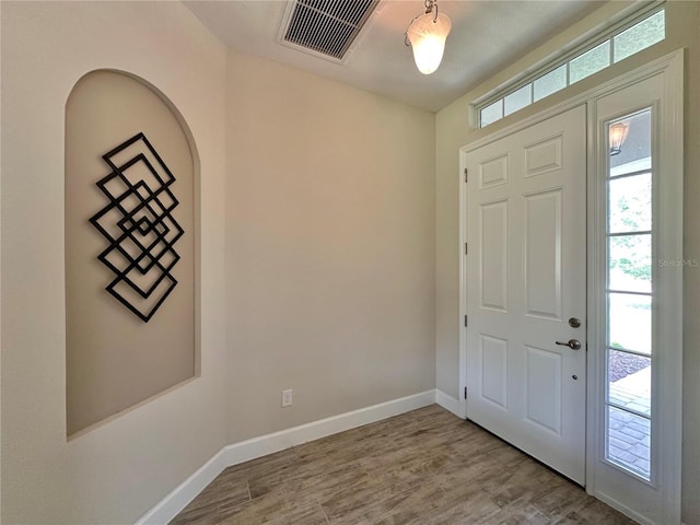 entryway featuring baseboards, wood finished floors, and visible vents