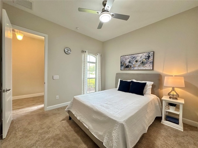 carpeted bedroom featuring baseboards, a ceiling fan, and visible vents