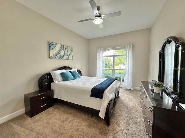 bedroom featuring light carpet, baseboards, and ceiling fan