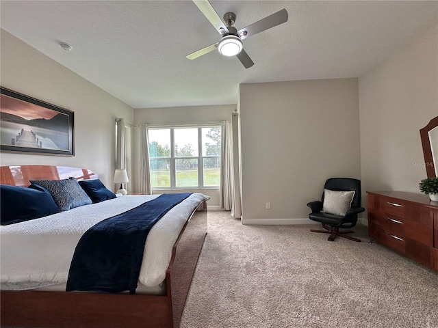 carpeted bedroom with a ceiling fan, baseboards, and a textured ceiling