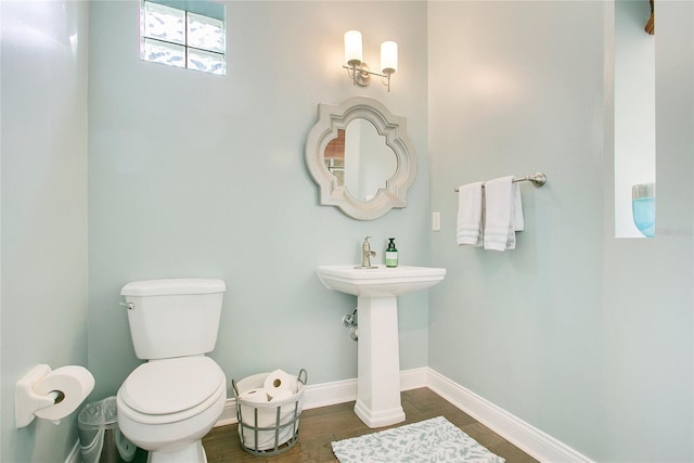 7003 Somerton Blvd, Orlando, FL 32819 - half bathroom featuring toilet, baseboards, and wood finished floors