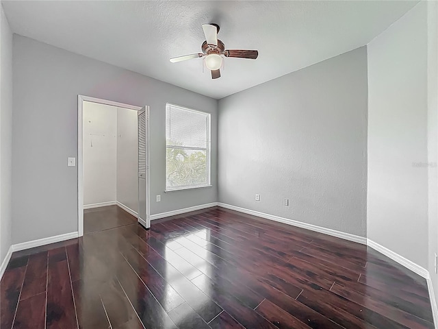 spare room featuring wood finished floors, ceiling fan, and baseboards