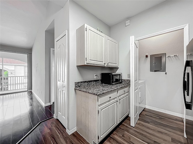 kitchen with baseboards, white cabinetry, dark wood-type flooring, and independent washer and dryer