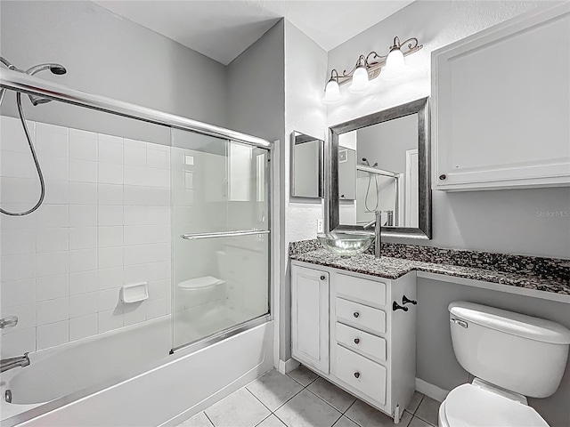 full bathroom with toilet, vanity, shower / bath combination with glass door, and tile patterned floors
