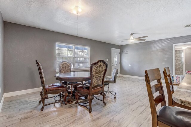 243 W Martin St, Apopka, FL 32712 - dining space featuring a textured ceiling, baseboards, a ceiling fan, and light wood-style floors