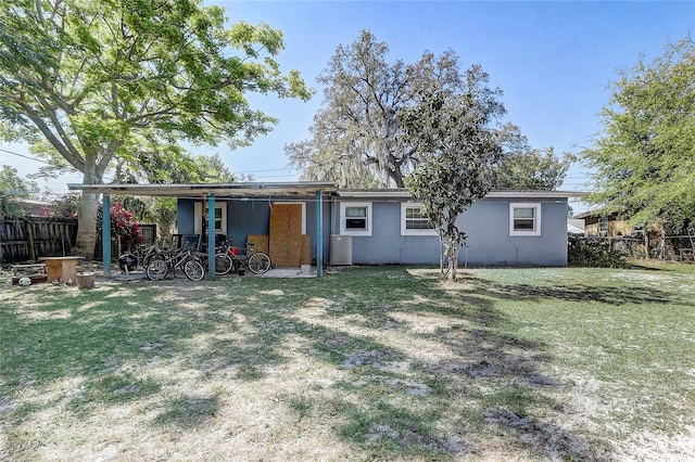 243 W Martin St, Apopka, FL 32712 - back of house featuring a yard, central AC unit, stucco siding, and fence