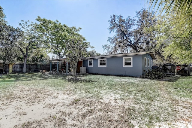 243 W Martin St, Apopka, FL 32712 - rear view of house featuring stucco siding, fence, and a lawn