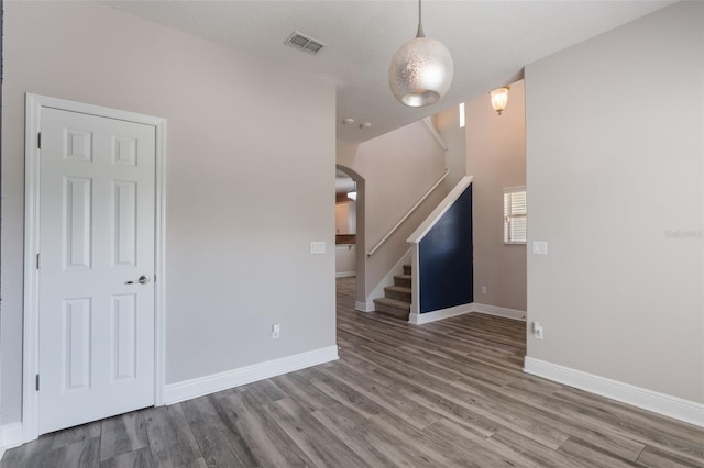 1197 Tallow Rd, Apopka, FL 32703 - unfurnished living room with wood finished floors, arched walkways, baseboards, and stairway