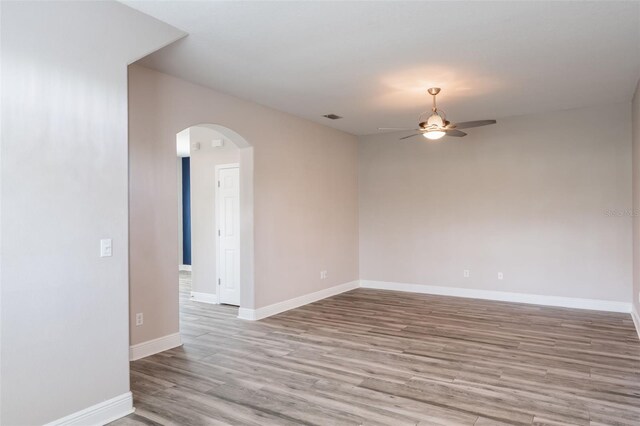 1197 Tallow Rd, Apopka, FL 32703 - unfurnished room with a ceiling fan, arched walkways, wood finished floors, and baseboards