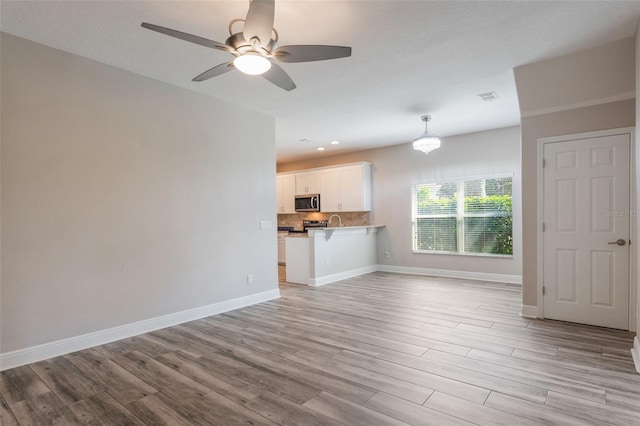 1197 Tallow Rd, Apopka, FL 32703 - unfurnished living room featuring light wood finished floors, baseboards, ceiling fan, recessed lighting, and a sink