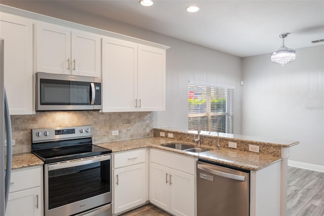 1197 Tallow Rd, Apopka, FL 32703 - kitchen featuring stainless steel appliances, light wood-type flooring, a peninsula, backsplash, and recessed lighting