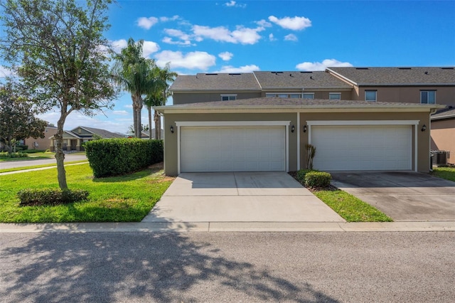 1197 Tallow Rd, Apopka, FL 32703 - townhome / multi-family property featuring stucco siding, concrete driveway, a front yard, and central air condition unit