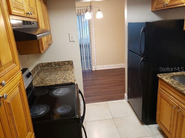 4779 S Texas Ave Unit 4779C, Orlando, FL 32839 - kitchen featuring brown cabinetry, under cabinet range hood, stainless steel range with electric stovetop, and freestanding refrigerator