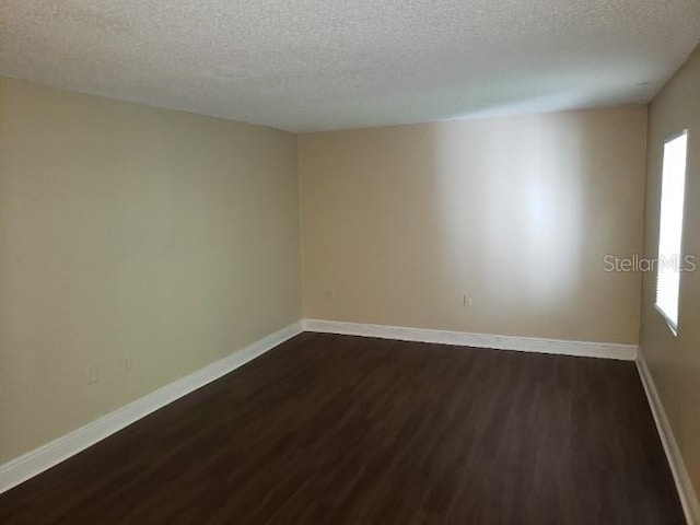 4779 S Texas Ave Unit 4779C, Orlando, FL 32839 - unfurnished room featuring dark wood-type flooring, a wealth of natural light, and baseboards