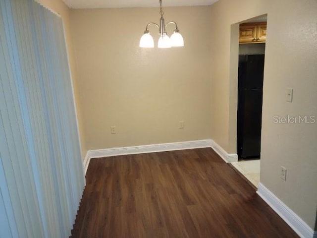 4779 S Texas Ave Unit 4779C, Orlando, FL 32839 - empty room featuring baseboards, wood finished floors, and an inviting chandelier